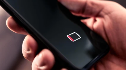 Un teléfono móvil con el símbolo de batería baja iluminado en la pantalla